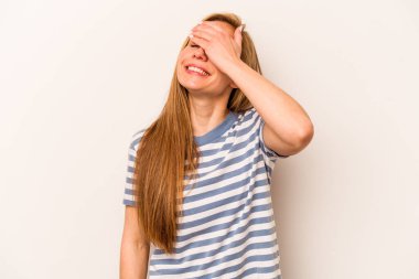 Beyaz arka planda soyutlanmış beyaz bir kadın ellerini başının üstünde tutarak neşeyle gülüyor. Mutluluk kavramı.