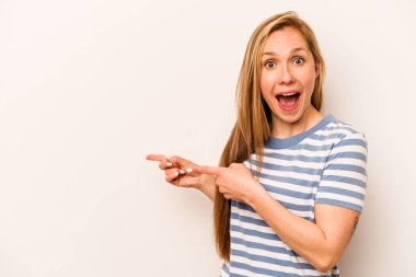 Beyaz arka planda izole edilmiş beyaz tenli genç bir kadın işaret parmağıyla işaret ederek heyecanlanıyor..