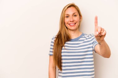 Beyaz arka planda izole edilmiş beyaz tenli genç bir kadın bir numarayı parmağıyla gösteriyor..