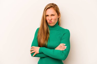 Beyaz arka planda izole edilmiş, hoşnutsuzca kaşlarını çatmış, kollarını kavuşturmuş genç beyaz bir kadın..