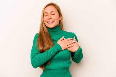 Beyaz arka planda izole edilmiş beyaz tenli genç bir kadın, dostane bir ifadeye sahip, avuçlarını göğsüne bastırıyor. Aşk konsepti.