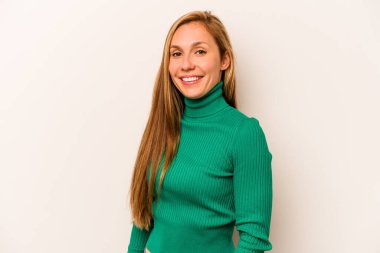 Beyaz arka planda izole edilmiş beyaz tenli genç bir kadın ellerini kalçasından ayırmıyor..