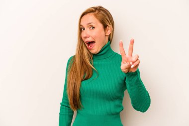 Beyaz arka planda izole edilmiş genç beyaz kadın iki numarayı parmaklarıyla gösteriyor..