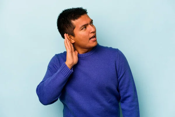 Mladý Hispánec Izolovaný Modrém Pozadí Snaží Poslouchat Klepy — Stock fotografie