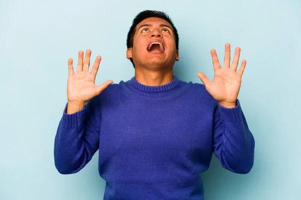Mladý Hispánec Izolovaný Modrém Pozadí Křičící Nebi Vzhlíží Frustrovaný — Stock fotografie