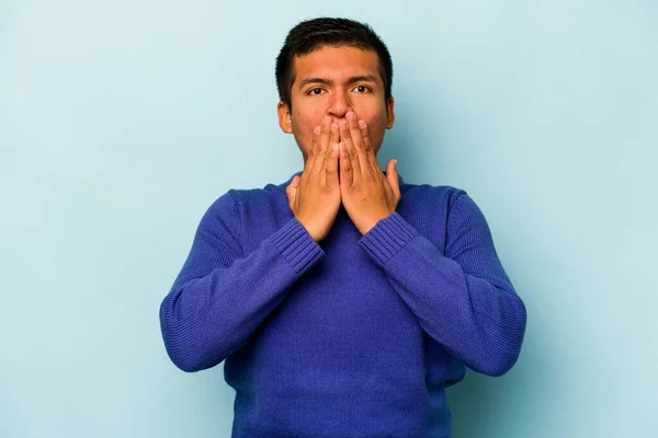 Jovem Hispânico Homem Isolado Fundo Azul Chocado Cobrindo Boca Com — Fotografia de Stock
