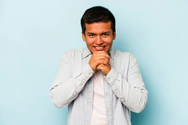Mladý Hispánec Izolovaný Modrém Pozadí Drží Ruce Pod Bradou Šťastně — Stock fotografie