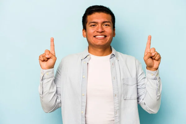 Joven Hombre Hispano Aislado Sobre Fondo Azul Indica Con Ambos —  Fotos de Stock