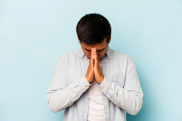 Молодий Іспаномовний Чоловік Ізольований Синьому Фоні Молячись Демонструючи Відданість Релігійний — стокове фото