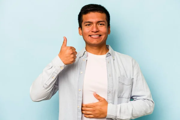 Mladý Hispánec Izolovaný Modrém Pozadí Dotýká Bříška Jemně Usmívá Pojídá — Stock fotografie