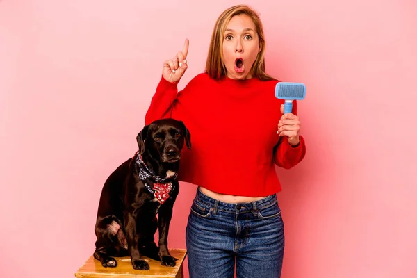 Young Caucasian Woman Combing Dog Isolated Pink Background Having Idea — Foto de Stock