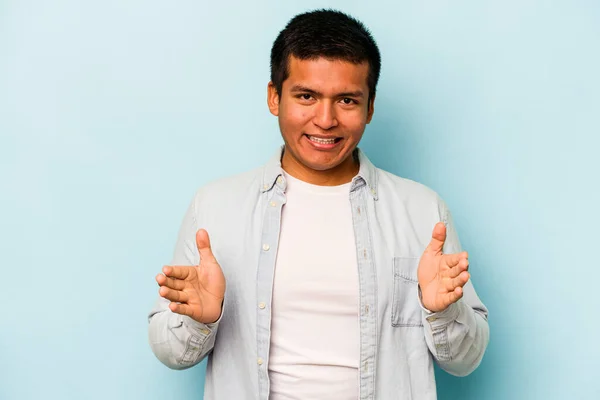 Young Hispanic Man Isolated Blue Background Holding Something Both Hands — стоковое фото