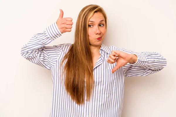 Beyaz arka planda izole edilmiş genç beyaz bir kadın baş parmağını kaldırıyor ve baş parmağını aşağı gösteriyor, zor seçim konsepti.