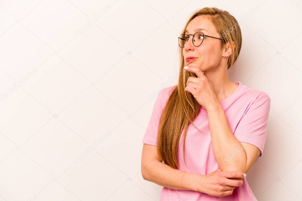 Young caucasian woman isolated on white background relaxed thinking about something looking at a copy space.