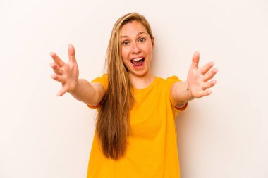 Beyaz arka planda izole genç beyaz kadın zaferi ya da başarıyı kutluyor, şaşırıyor ve şok oluyor..
