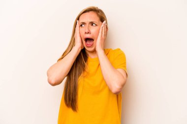 Beyaz arka planda izole edilmiş genç beyaz bir kadın. Kulakları kulaklarıyla kapatıyor. Çok fazla ses duymamaya çalışıyor..