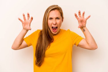 Beyaz arka planda izole edilmiş genç beyaz kadın pençelerini kedi taklidi yaparken gösteriyor, agresif bir hareket..