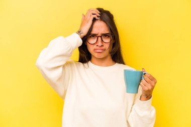 Sarı arka planda saklanmış bir kupa tutan genç İspanyol kadın şok geçiriyordu. Önemli bir toplantıyı hatırladı..