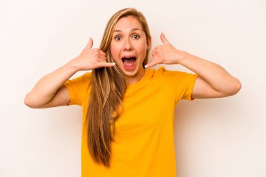 Beyaz arka planda izole edilmiş genç beyaz kadın parmaklarıyla bir cep telefonu hareketi gösteriyor..