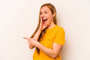 Beyaz arka planda izole edilmiş genç beyaz bir kadın bir dedikodu söylüyor, bir haber sunuyor..