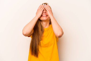 Beyaz arka planda soyutlanmış beyaz bir kadın ellerini başının üstünde tutarak neşeyle gülüyor. Mutluluk kavramı.