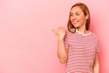 Pembe arka plan noktalarında izole edilmiş genç beyaz kadın başparmak uzakta, gülüyor ve kaygısız..