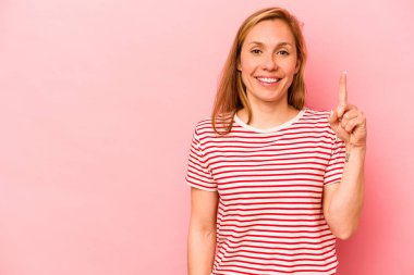 Pembe arka planda izole edilmiş beyaz bir kadın bir numarayı parmağıyla gösteriyor..