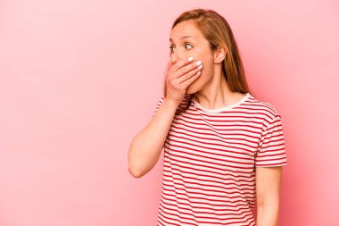 Pembe arka planda izole edilmiş beyaz bir kadın. Düşünceli bir şekilde ağzıyla ağzını kapatan bir fotokopi odasına bakıyor..