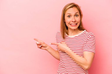 Pembe arka planda izole edilmiş beyaz bir kadın işaret parmağıyla bir fotokopi alanını işaret ederek şok geçirdi..