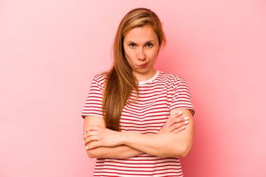 Pembe arka planda soyutlanmış beyaz bir kadın hoşnutsuzca kaşlarını çatmış, kollarını kavuşturmuş..