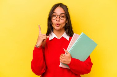 Genç İspanyol öğrenci, sarı arka planda izole edilmiş. Harika bir fikri var. Yaratıcılık kavramı..