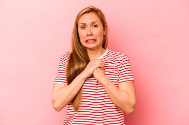 Pembe arka planda izole edilmiş genç beyaz kadın korkmuş ve korkmuş..