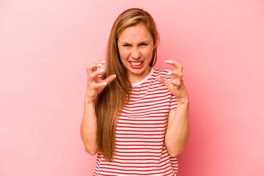 Pembe arka planda izole edilmiş genç beyaz kadın gergin elleriyle çığlık atıyor..