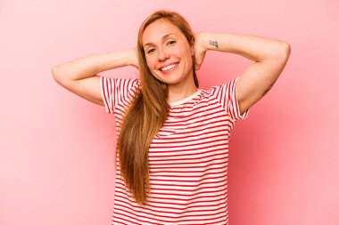 Pembe arka planda izole edilmiş genç beyaz kadın kollarını uzatıyor, rahat bir konumda..