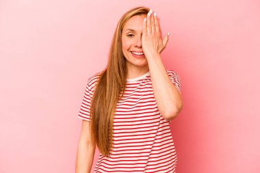 Pembe arka planda izole edilmiş beyaz bir kadın yüzünün yarısını palmiye ile örterek eğleniyor..