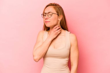 Pembe arka planda izole edilmiş genç beyaz kadın virüs veya enfeksiyon yüzünden boğazında ağrı hissediyor..