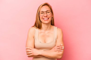 Genç beyaz kadın pembe arka planda izole edilmiş gülüyor ve eğleniyor..