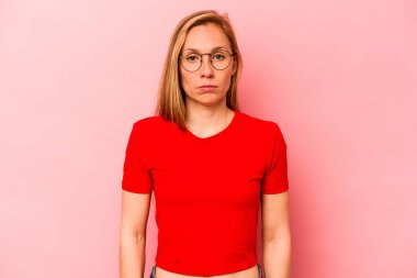 Pembe arka planda soyutlanmış beyaz bir kadın üzgün, ciddi bir yüz, mutsuz ve hoşnutsuz..