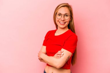 Pembe arka planda izole edilmiş genç beyaz kadın mutlu, güler yüzlü ve neşeli..