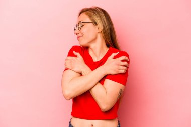 Pembe arka planda soyutlanmış beyaz bir kadın. Kucaklaşma, kaygısız gülümseme ve mutluluk..