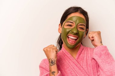 Beyaz arka planda izole edilmiş yüz maskesi takan genç İspanyol kadın zafer kazandıktan sonra yumruğunu kaldırdı..