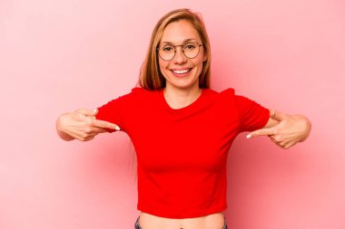 Pembe arka planda izole edilmiş genç beyaz kadın parmaklarıyla aşağıya doğru, olumlu bir his..