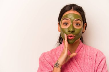 Beyaz arka planda izole edilmiş yüz maskesi takan genç İspanyol kadın gizli bir sıcak fren haberinin olduğunu söylüyor.