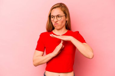 Pembe arka planda izole edilmiş genç beyaz kadın bir mola hareketi gösteriyor..