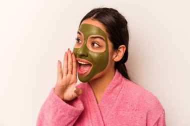 Beyaz arka planda izole edilmiş yüz maskesi takan genç İspanyol kadın bağırıyor ve avuç içini açık tutuyor..