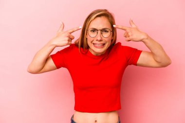 Pembe arka planda izole edilmiş beyaz bir kadın işaret parmağıyla hayal kırıklığı jesti gösteriyor..