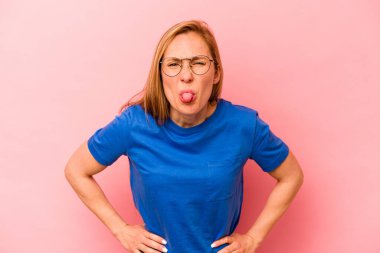 Pembe arka planda izole edilmiş beyaz bir kadın. Komik ve dost canlısı bir dil uzatıyor..