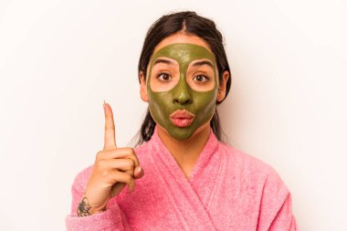 Beyaz arka planda izole edilmiş yüz maskesi takan genç İspanyol kadının harika bir fikri var, yaratıcılık kavramı..