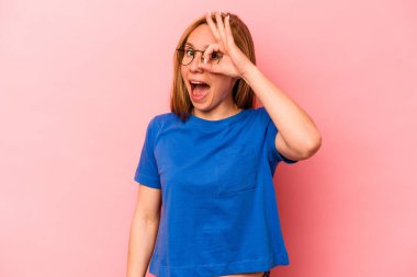 Pembe arka planda izole edilmiş beyaz bir kadın heyecanlı..