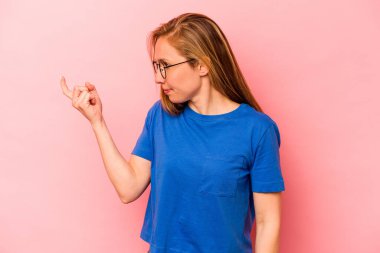 Pembe arka planda izole edilmiş genç beyaz kadın sanki seni davet ediyormuş gibi seni işaret ediyor..